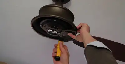 Electrician installing ceiling fan mounting bracket and fixture in Escondido, CA