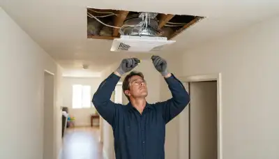 Technician installing a whole-house fan ceiling unit and insulated damper in Escondido, CA