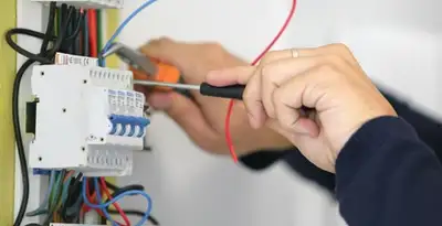 Electrician installing and adjusting circuit breakers in an electrical panel in Escondido, CA