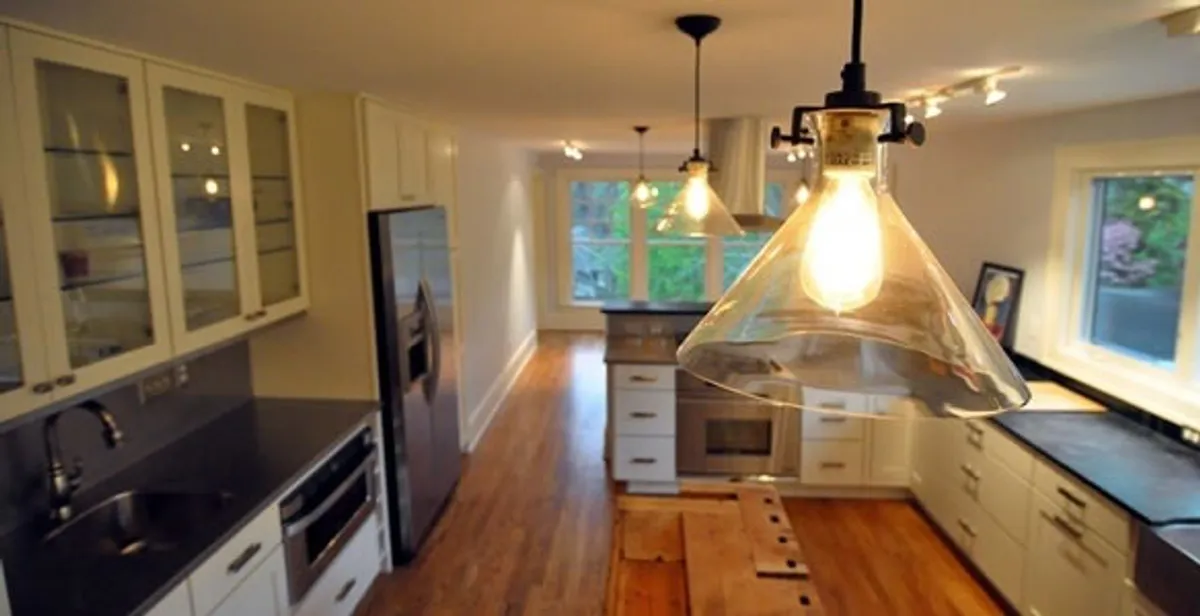 Residential electrician installing modern indoor light fixture in a home in Escondido, CA