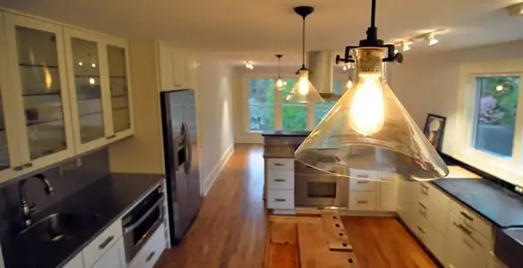 Residential electrician installing modern indoor light fixture in a home in Escondido, CA